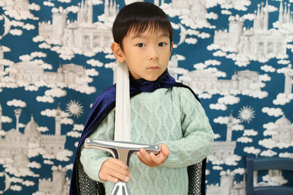 フランスのプリント布を背景にかっこいい騎士役を演じる５歳のおこさん