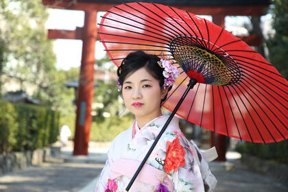 成人式の前撮り撮影を根津神社の境内で紅い唐傘をもって、自然光のなかで。