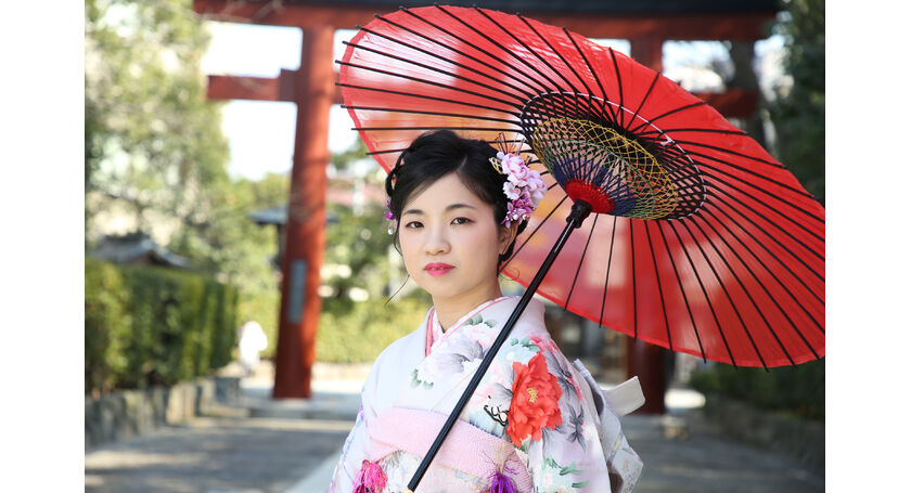 成人式の前撮り撮影を根津神社の境内で紅い唐傘をもって、自然光のなかで。